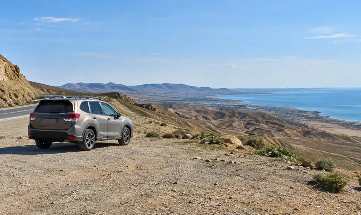 A parked SUV beside an arid coastal road outside Baku A parked SUV beside an arid coastal road outside Baku