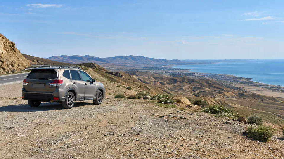 A parked SUV beside an arid coastal road outside Baku