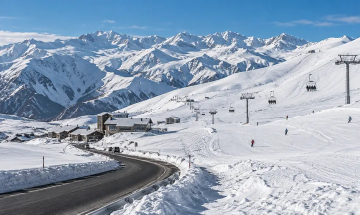 Ski slopes, chairlift and a plowed access road at Gudauri beneath snowy Caucasus ridges Ski slopes, chairlift and a plowed access road at Gudauri beneath snowy Caucasus ridges