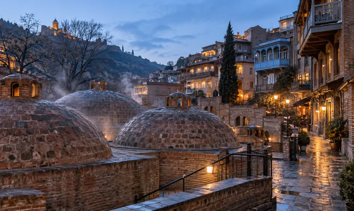 Brick sulfur-bath domes and warm old-town windows in Tbilisi at winter twilight Brick sulfur-bath domes and warm old-town windows in Tbilisi at winter twilight