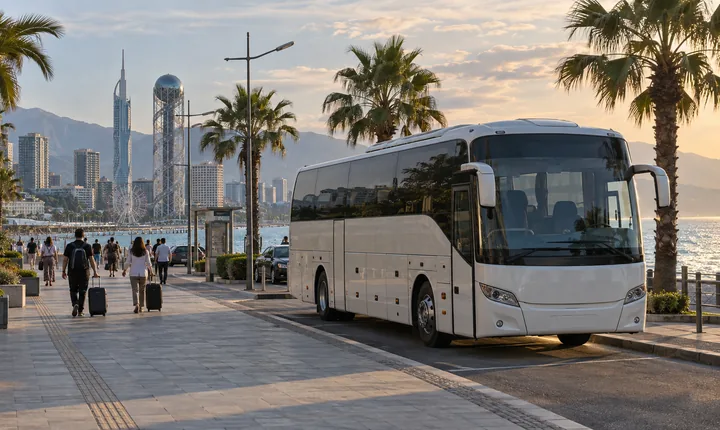An intercity coach at a coastal curbside bay with palm trees and the Black Sea beyond An intercity coach at a coastal curbside bay with palm trees and the Black Sea beyond