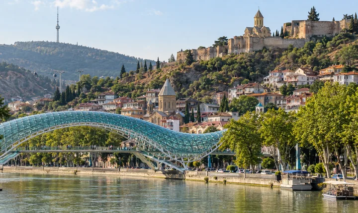 The curved glass Peace Bridge spans the Mtkvari River beside Tbilisi's Old Town The curved glass Peace Bridge spans the Mtkvari River beside Tbilisi's Old Town